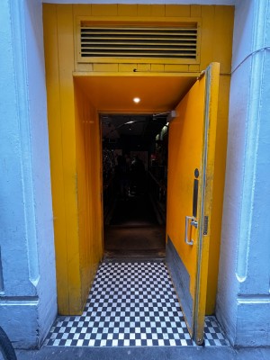 Yellow wooden door. Pull from silver handle on left to open.
