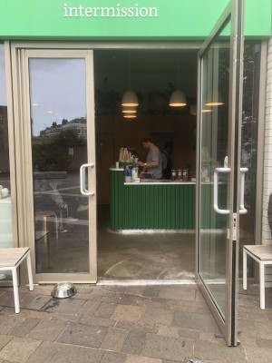 Glass doors with grey frame. Pull handle in centre to open.