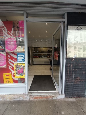 Glass door with grey metal frame. Push from left to open.