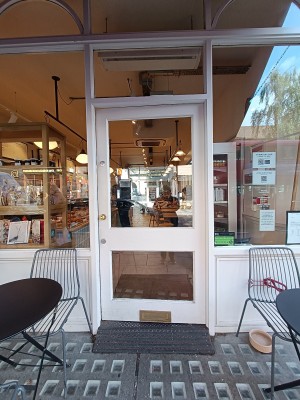 Glass door with white wooden frame. Push golden handle from left to open.