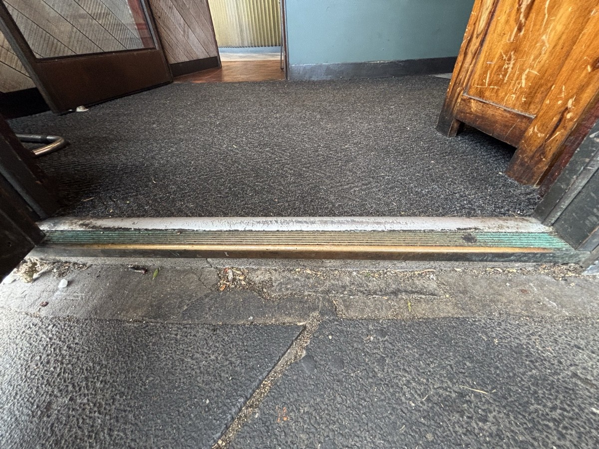 One step up at foot of door followed by doormat.