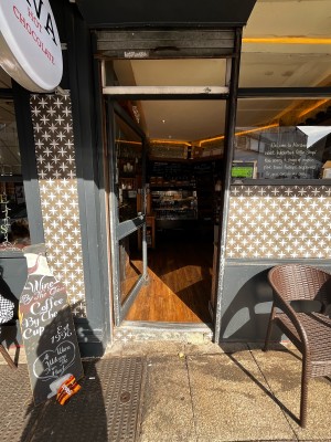 Step up to glass door with grey frame ahead. Push door from right to open.