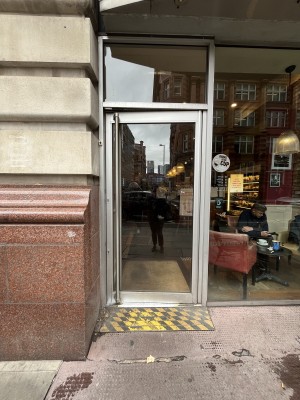 Glass door with silver handle. Push handle on left to open.