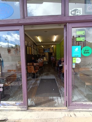 Glass door with purple wooden frame. Push from left to open.