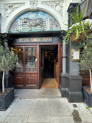 From sidewalk facing venue. Wooden door with glass panel ahead. Push from right to open.