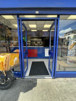 Glass doors with blue frame ahead. Push blue metal handles from centre to open.