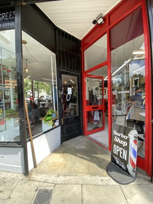 Glass door with  wooden frame ahead. Push from left to open