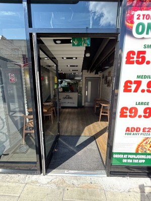 Glass door with black frame. Push from right to open.