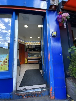 Glass door with blue wooden frame ahead. Push down metal handle on left to open