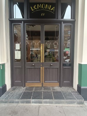 Glass doors with black, wooden frame ahead. Push from middle to open.