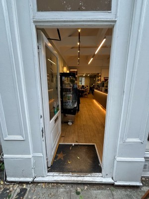 Grey door with glass panel ahead. Push from right to open.
