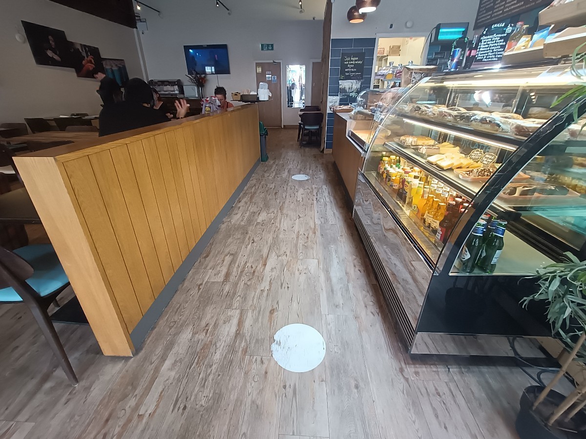 From right of wall divider, facing straight. Wall divider along left. Display and counter along right.
