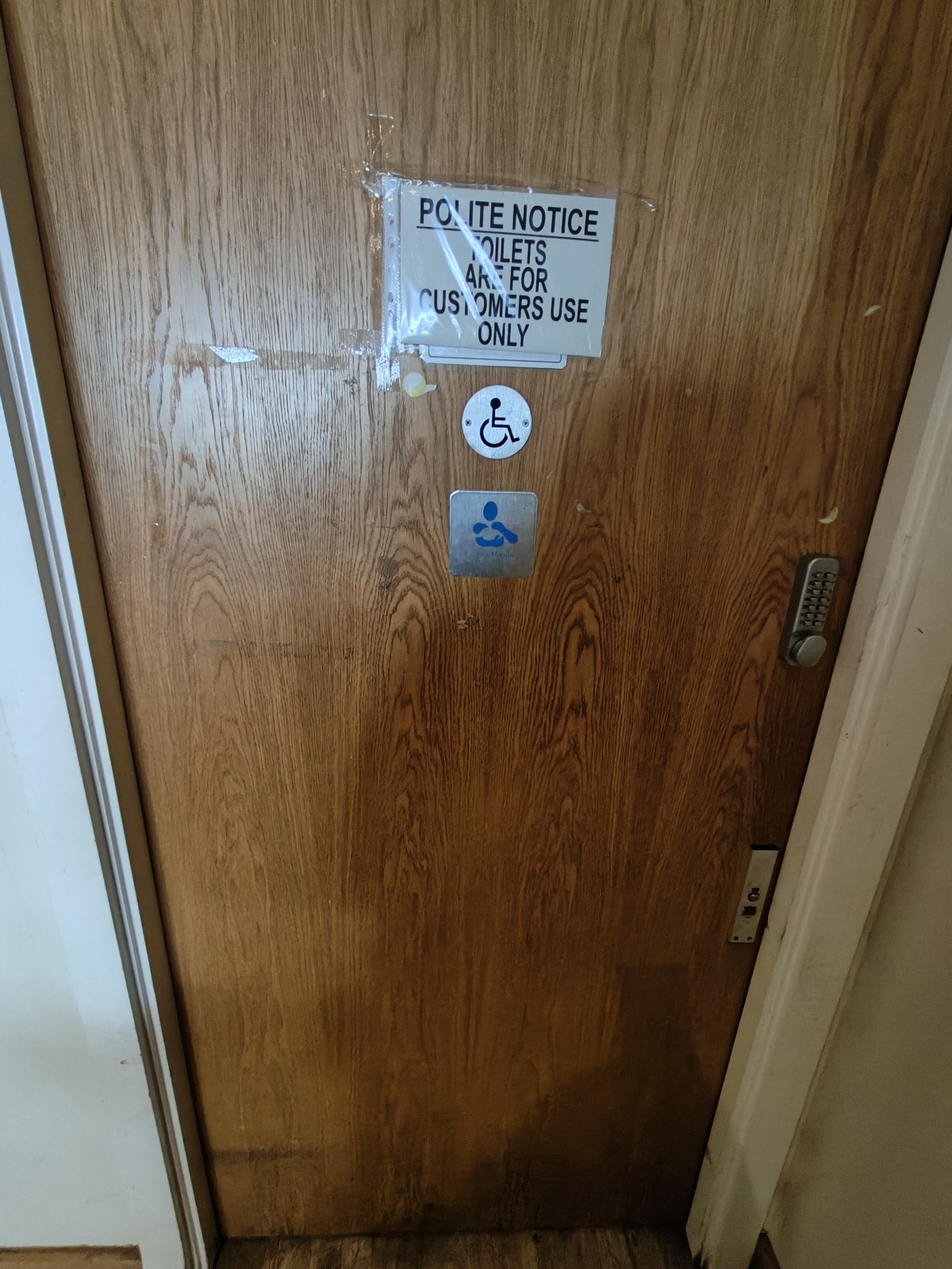From baby high chair facing left. Wooden toilet door ahead. Keycode pad on right. Push from right to open.
