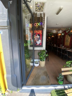Glass door with grey frame ahead. Push down metal handle on right to open