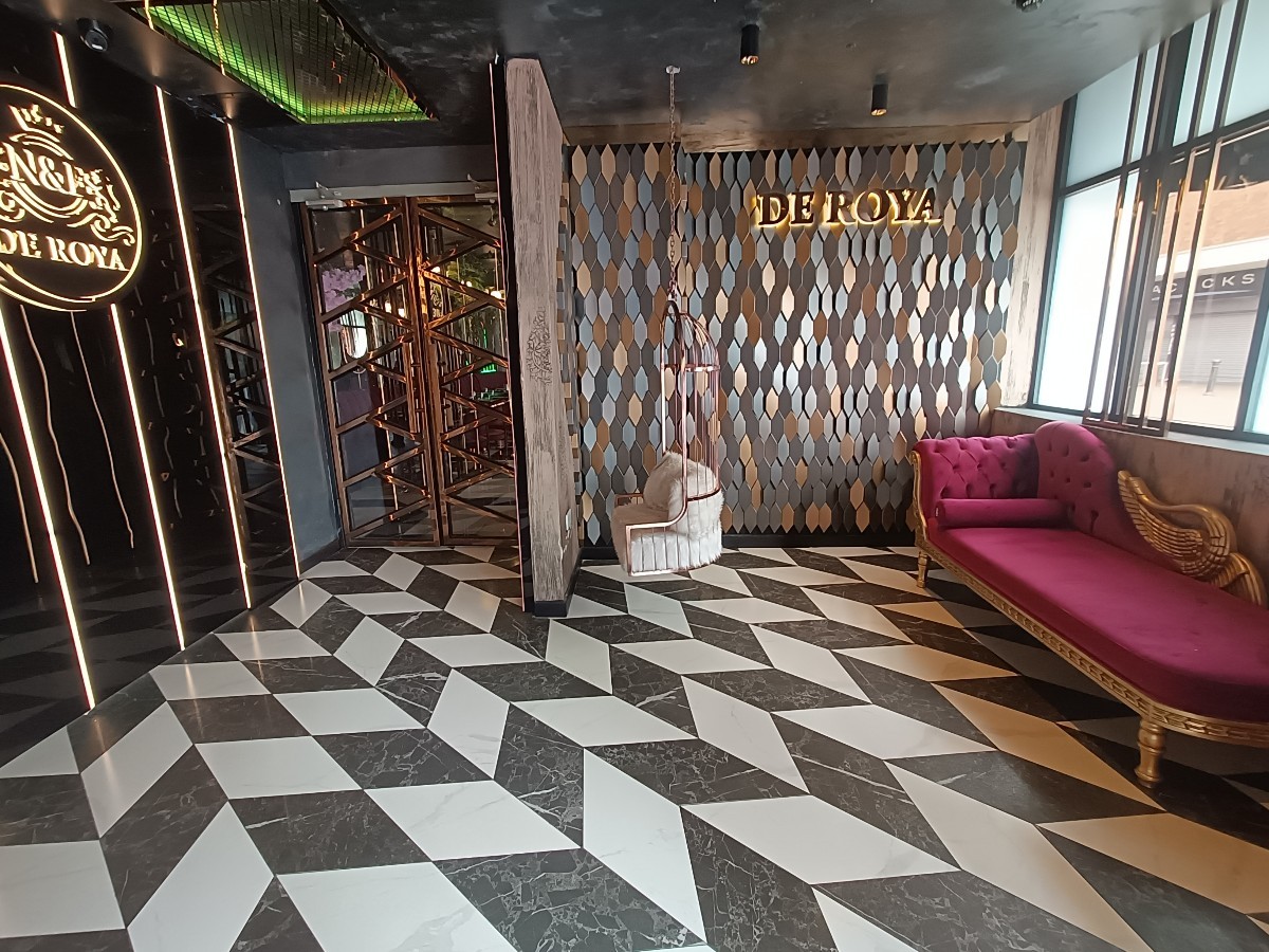 From welcome desk, facing straight. Benches along right. Swing at back. Wall divider to its left. Doorway at back left.