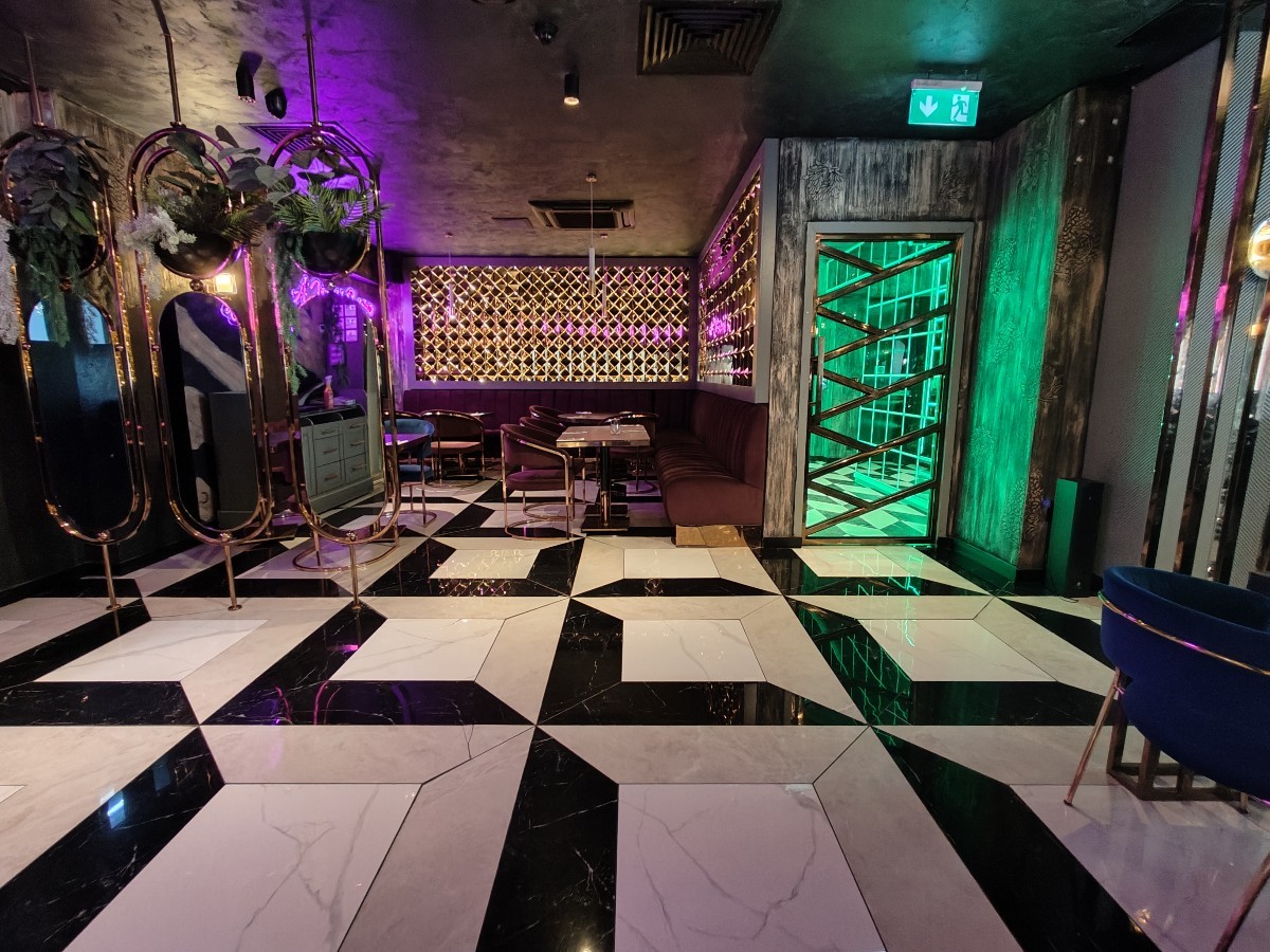 From end of bar facing straight. Path in centre to more seating. Mirror partition on left.