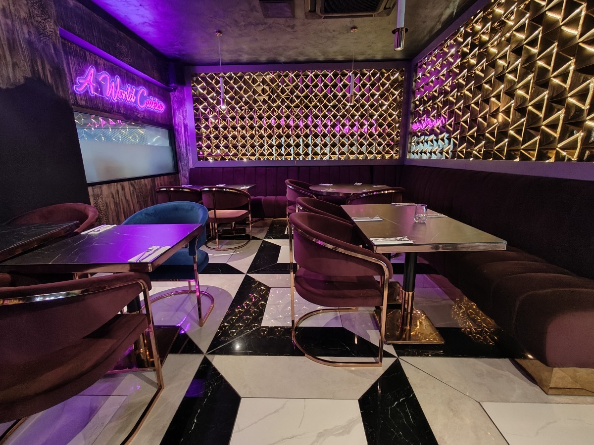 From mirror partition facing straight. Half booth on right and back. Tables and chairs on left.