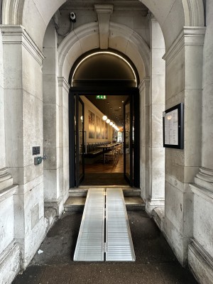 Opening ahead followed by glass doors with black frame. Push silver handles in centre to open.