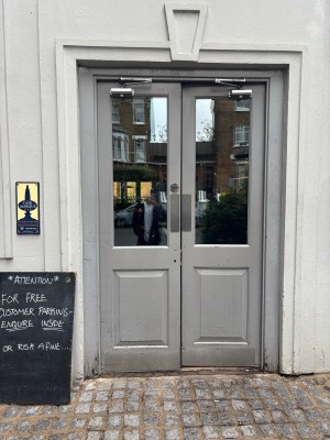Glass doors with grey frames. Push from centre to open.
