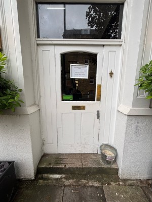 White door with glass panel ahead. Push from right to open.