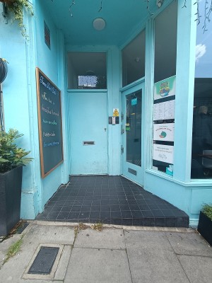 From street, facing venue. Opening ahead to doorway at back right.