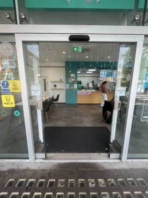 Glass doors with white frame. Slide automatically outwards to open.
