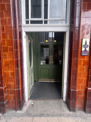 Light green preceding double doors with no handles. Push doors in centre to open.