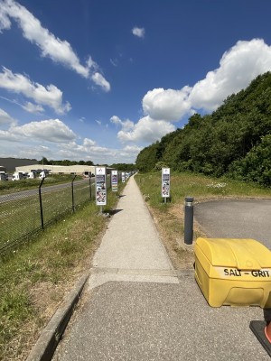 From car park three facing towards venue. Pedestrian path ahead. Path curves slightly right halfway.