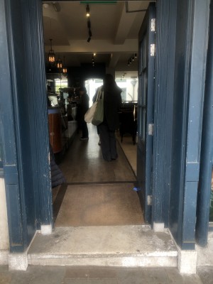 Glass door with wooden frame. Push handle on left to open.
