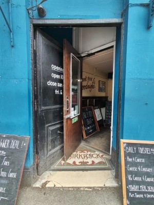 First preceding black door. Push from right to open.