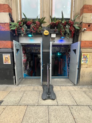 Two sets of grey doors ahead. Pull blue handles in centre to open. Standing sign in centre.