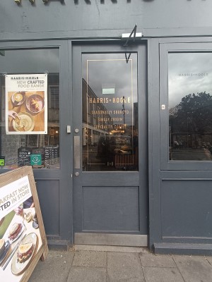 Glass door with grey wooden frame ahead. Push from left to open.
