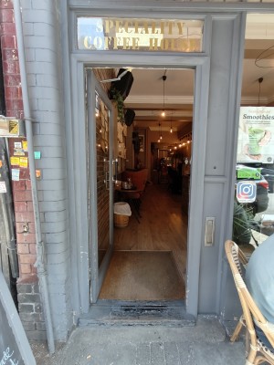 Grey framed glass door. Push black handle on right to open.