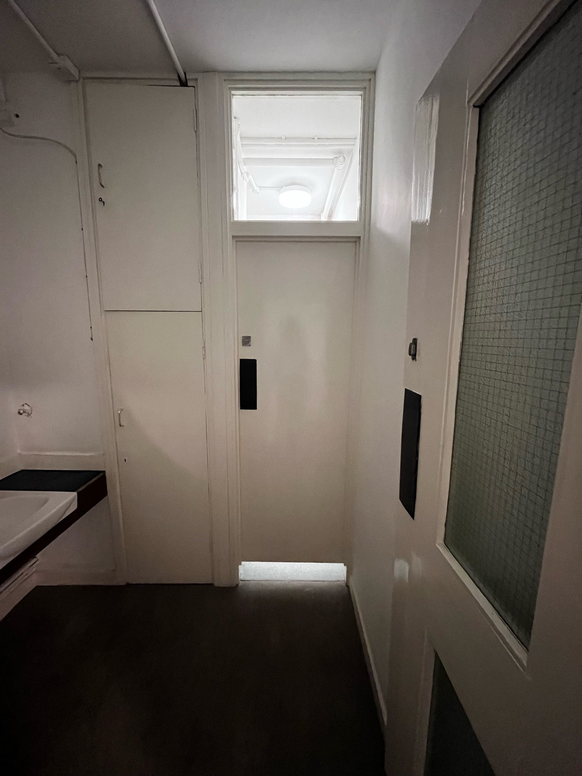 From preceding door facing straight. Path ahead to cubicle door. Push pad on left to open.