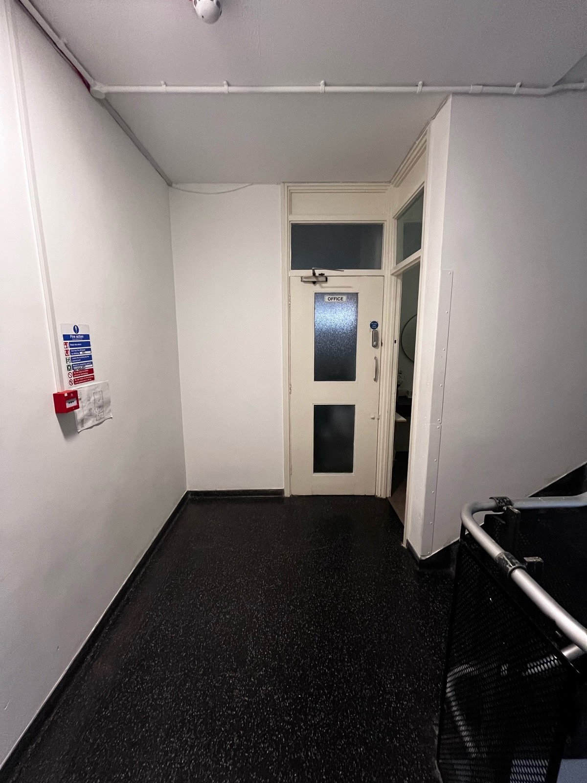 From top of second flight of stairs, facing right. Path ahead leads to staff door at back and toilet door ahead on right.