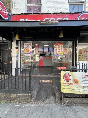 From sidewalk facing venue. Opening ahead. Glass door on back. Push via handle on left to open.