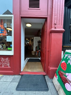 Red wooden door ahead. Push from left to open.