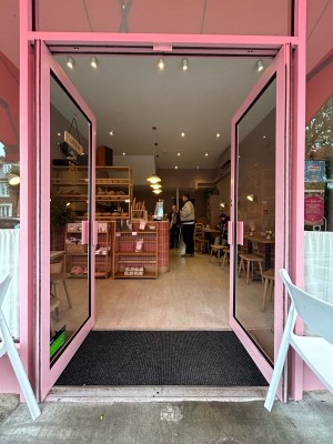 Glass doors with pink frame. Push pink metal handles in centre to open.