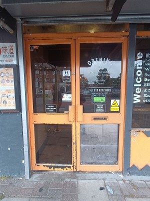 Glass doors with brown, wooden frame. Push handles in middle to open.