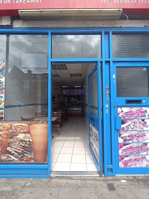 Glass door with blue, metal frame ahead. Push from left to open.