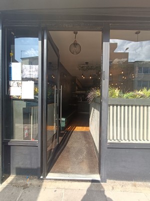 Glass door with silver handle on right, push to open.