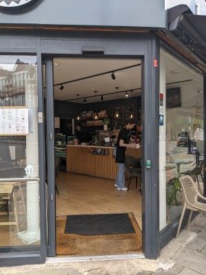 Glass door with grey frame. Sides left to open. Button to right of door.