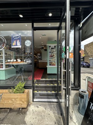 Glass door with black frame. Pull silver handle from left to open.