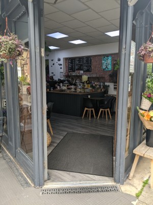 Glass door with grey frame. Push from right to open.