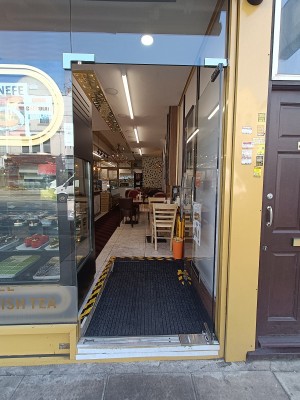 Glass door with silver handle on left. Push from left to open.