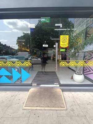 Glass door with silver handle on right. Push to open.