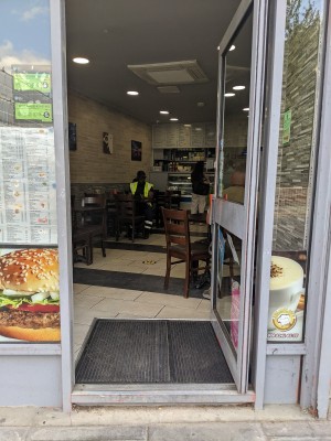 Glass door with metal frame and metal handle. Push from left to open.