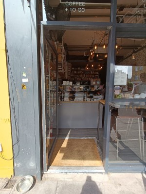 Glass door with grey metal frame ahead. Push from right to open.