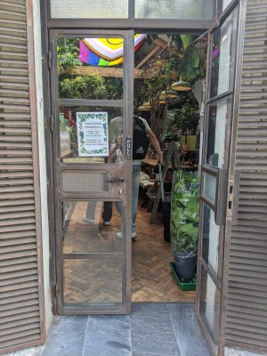 Glass doors with metal frame ahead. Pull metal handles in centre to open.