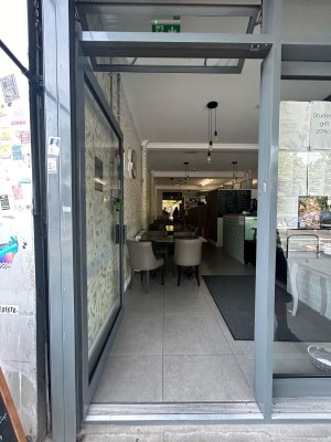 Grey framed glass door ahead. Push grey handle on right to open.